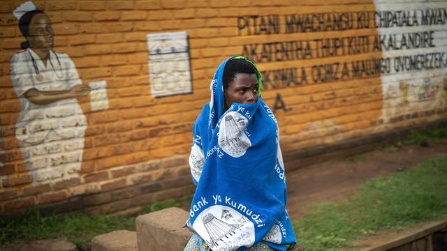 Eine Frau wartet vor einer Klinik in Migowi in Malawi darauf, im Rahmen eines Pilotprojekts der WHO gegen Malaria geimpft zu werden