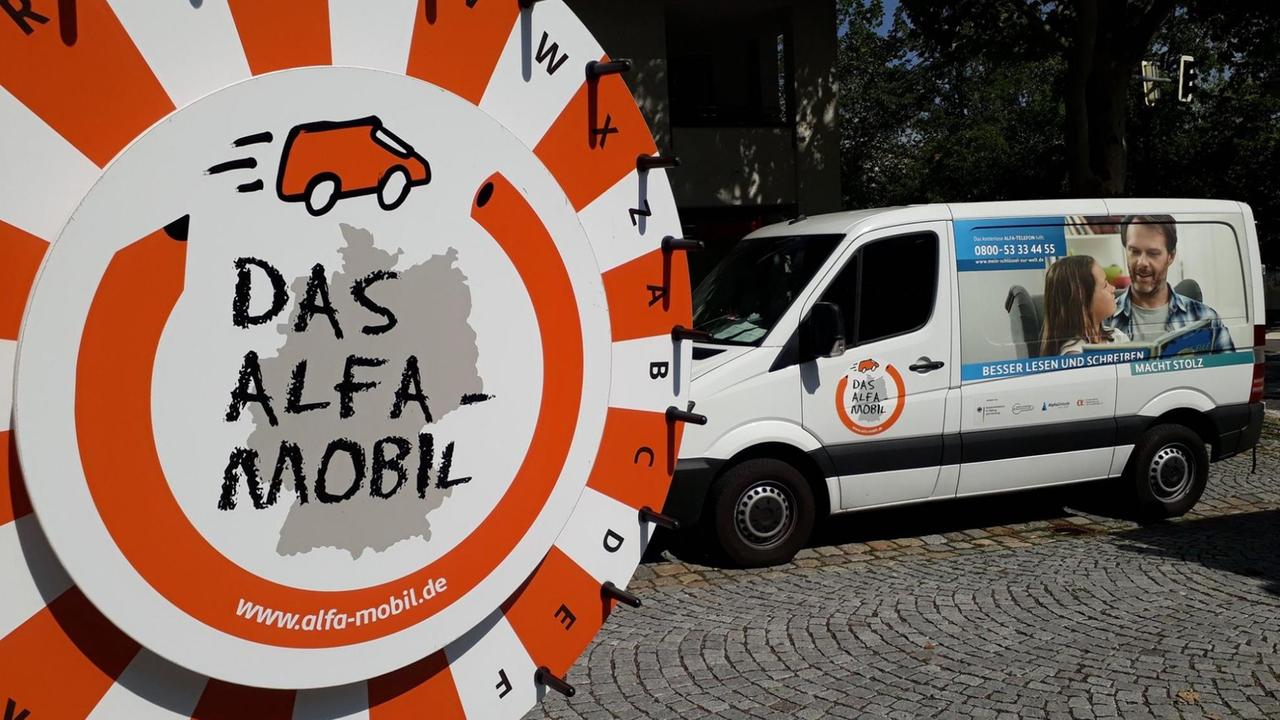 Auto und Schild Alfa-Mobil: ein mobiler Infostand für Alphabetisierungskampagne