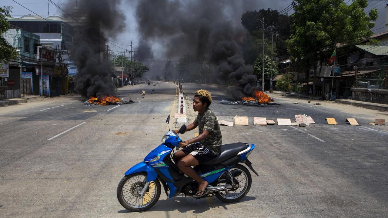 Am 31. März 2021 fährt ein Mann während gewaltsamer Proteste auf einem Motorrad über eine Straße in Rangun, Myanmar