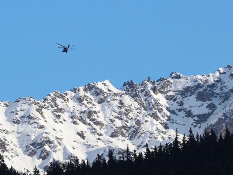 Zwei Hubschrauber im Anflug auf Davos, im Hintergrund schneebedeckte Berge.