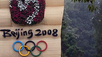 Ein chinesisches Paar spaziert in einem Park in Peking an einem Olympia-Logo vorbei. Ein chinesisches Paar spaziert in einem Park in Peking an einem Olympia-Logo vorbei.
