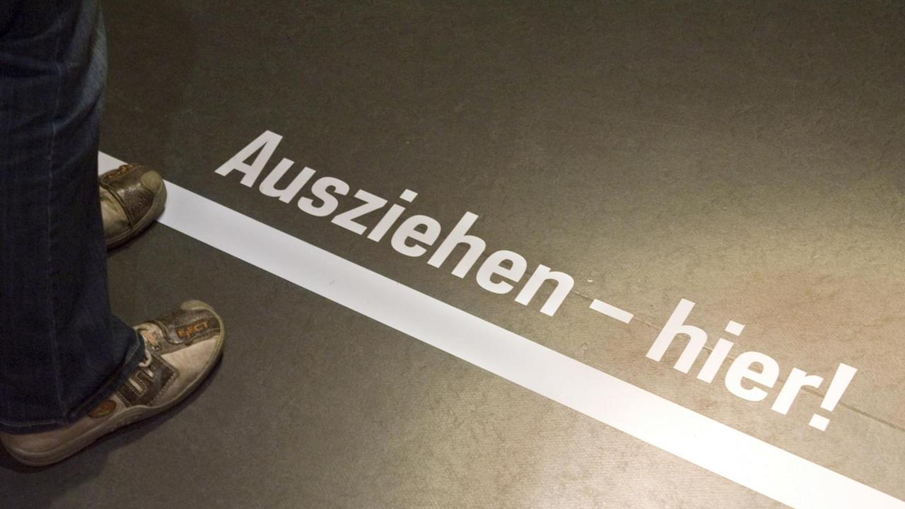 ARCHIV - Ein Besucher steht am 07.11.2009 vor der Line mit der Aufschrift «Ausziehen hier» in einem Raum des ehemaligen Geschlossenen Jugendwerkhofes Torgau in der heutigen Gedenkstätte in Torgau (Sachsen). Seit zwei Jahren können ehemalige DDR-Heimkinder, denen Unrecht geschah, Hilfen aus einem Entschädigungsfonds erreichen, am 30. September endet die Frist. Foto: Peter Endig/dpa (zu dpa «Land gibt 1,5 Millionen für Aufstockung des DDR-Heimkinder-Fonds» vom 12.08.2014) | Verwendung weltweit ARCHIV - Ein Besucher steht am 07.11.2009 vor der Line mit der Aufschrift «Ausziehen hier» in einem Raum des ehemaligen Geschlossenen Jugendwerkhofes Torgau in der heutigen Gedenkstätte in Torgau (Sachsen). Seit zwei Jahren können ehemalige DDR-Heimkinder, denen Unrecht geschah, Hilfen aus einem Entschädigungsfonds erreichen, am 30. September endet die Frist. Foto: Peter Endig/dpa (zu dpa «Land gibt 1,5 Millionen für Aufstockung des DDR-Heimkinder-Fonds» vom 12.08.2014) | Verwendung weltweit