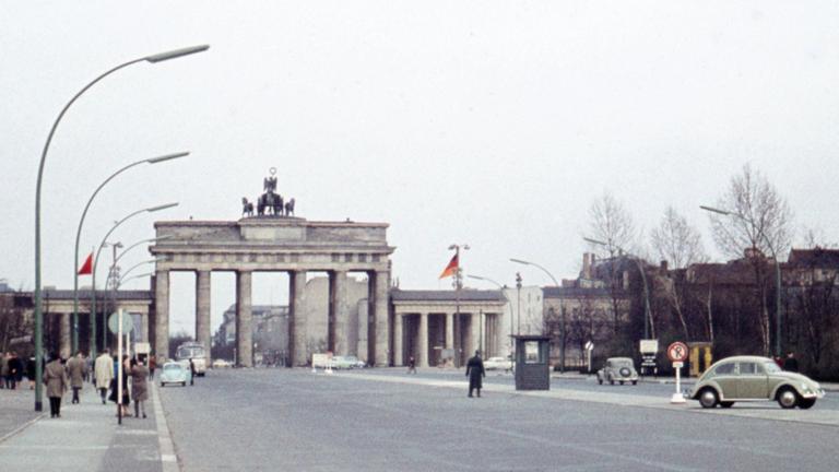Blasse historische Fotografie aus dem Jahr 1961 vom Platz vor dem Brandenburger Tor, auf dem ein Wachhäuschen platziert ist.