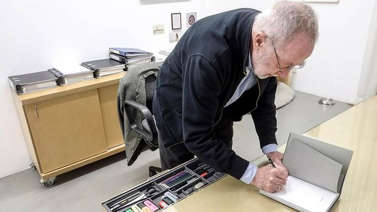 Der Maler Gerhard Richter signiert ein Buch