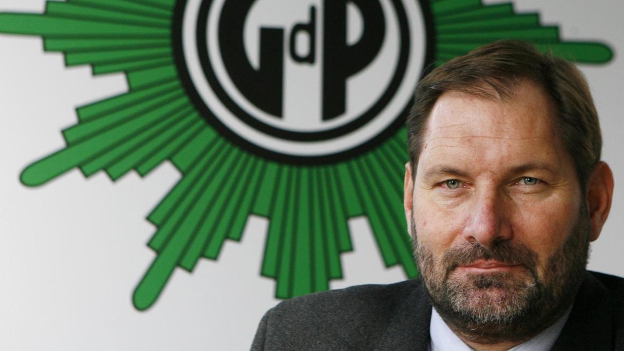 Jörk Radek blickt in die Kamera, hinter ihm hängt das Logo der Gewerkschaft GdP. Jörk Radek blickt in die Kamera, hinter ihm hängt das Logo der Gewerkschaft GdP.