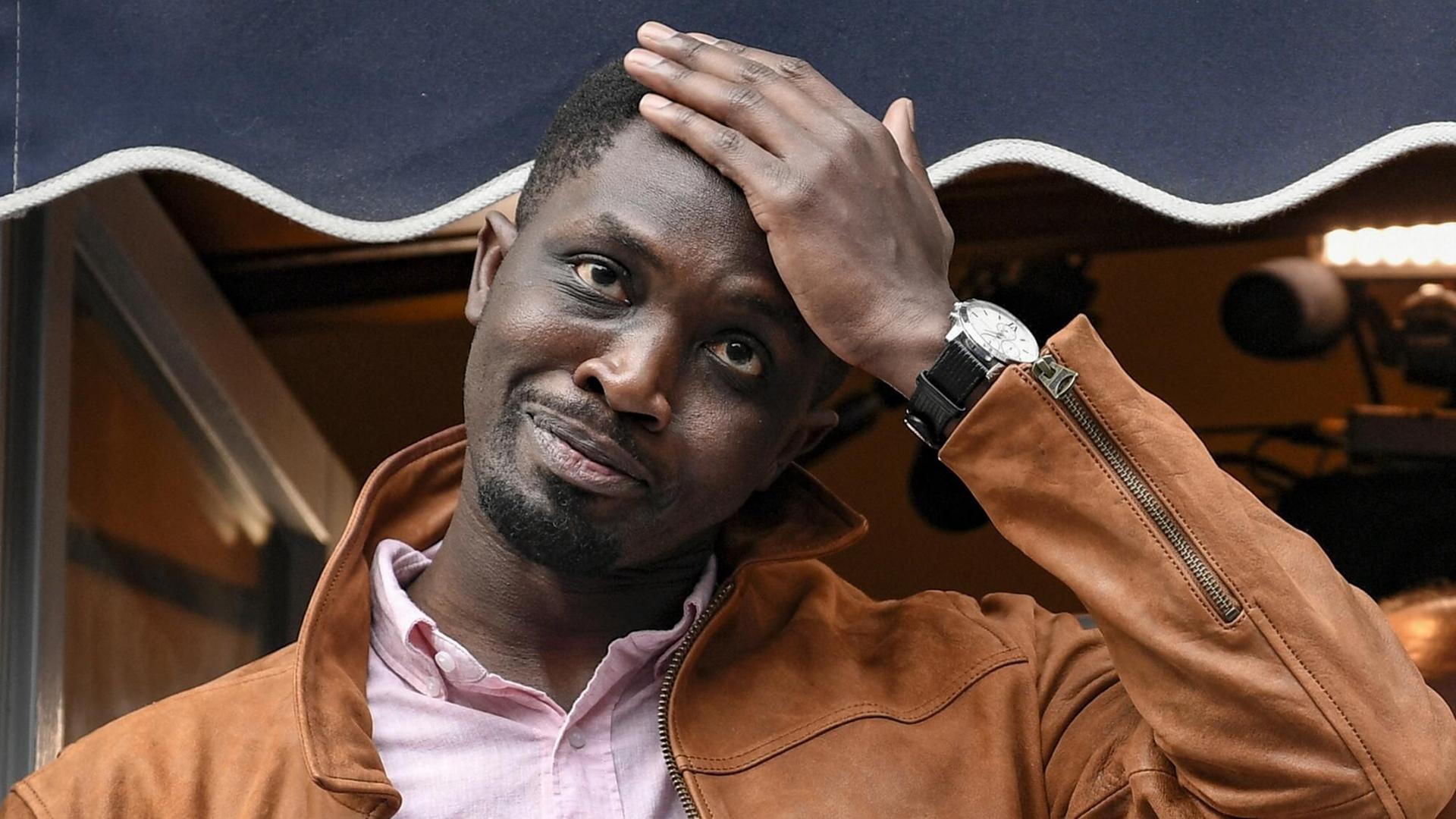 Der senegalesische Schriftsteller Mohamed Mbougar Sarr hält seine Hand am Kopf nachdem er den Prix Goncourt am 03.11.2021 in Paris überreicht bekommen hat. Der senegalesische Schriftsteller Mohamed Mbougar Sarr hält seine Hand am Kopf nachdem er den Prix Goncourt am 03.11.2021 in Paris überreicht bekommen hat.