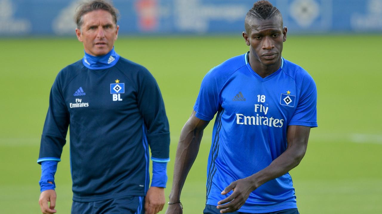 Der Flüchtling Bakery Jatta (r.), der einen Profivertrag beim HSV unterschrieben hat, wird von Hamburgs Trainer Bruno Labbadia beim Training beobachtet. Der Flüchtling Bakery Jatta (r.), der einen Profivertrag beim HSV unterschrieben hat, wird von Hamburgs Trainer Bruno Labbadia beim Training beobachtet.