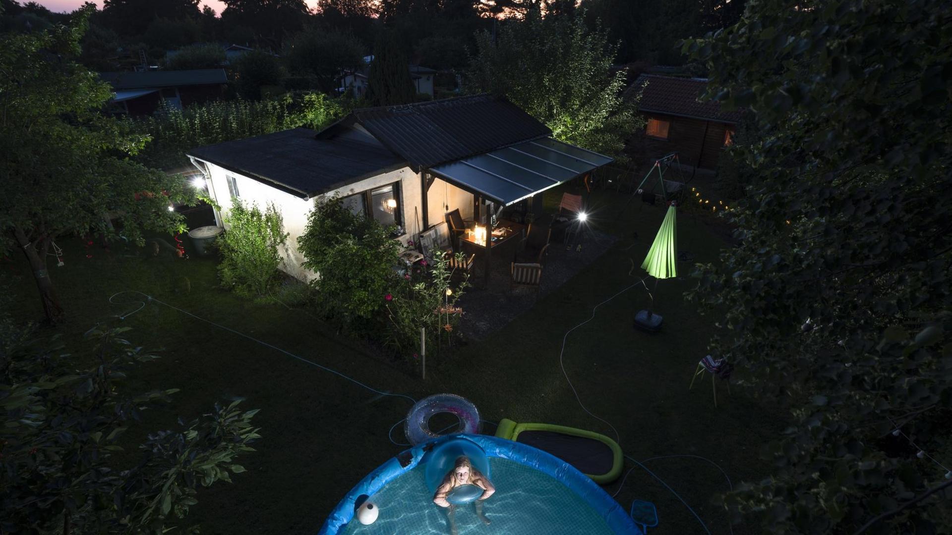 Von Oben ein Blick in das Leben in einer Berliner Kleingartenkolonie mit einer Parzellenpächterin in ihrem Pool. Von Oben ein Blick in das Leben in einer Berliner Kleingartenkolonie mit einer Parzellenpächterin in ihrem Pool.