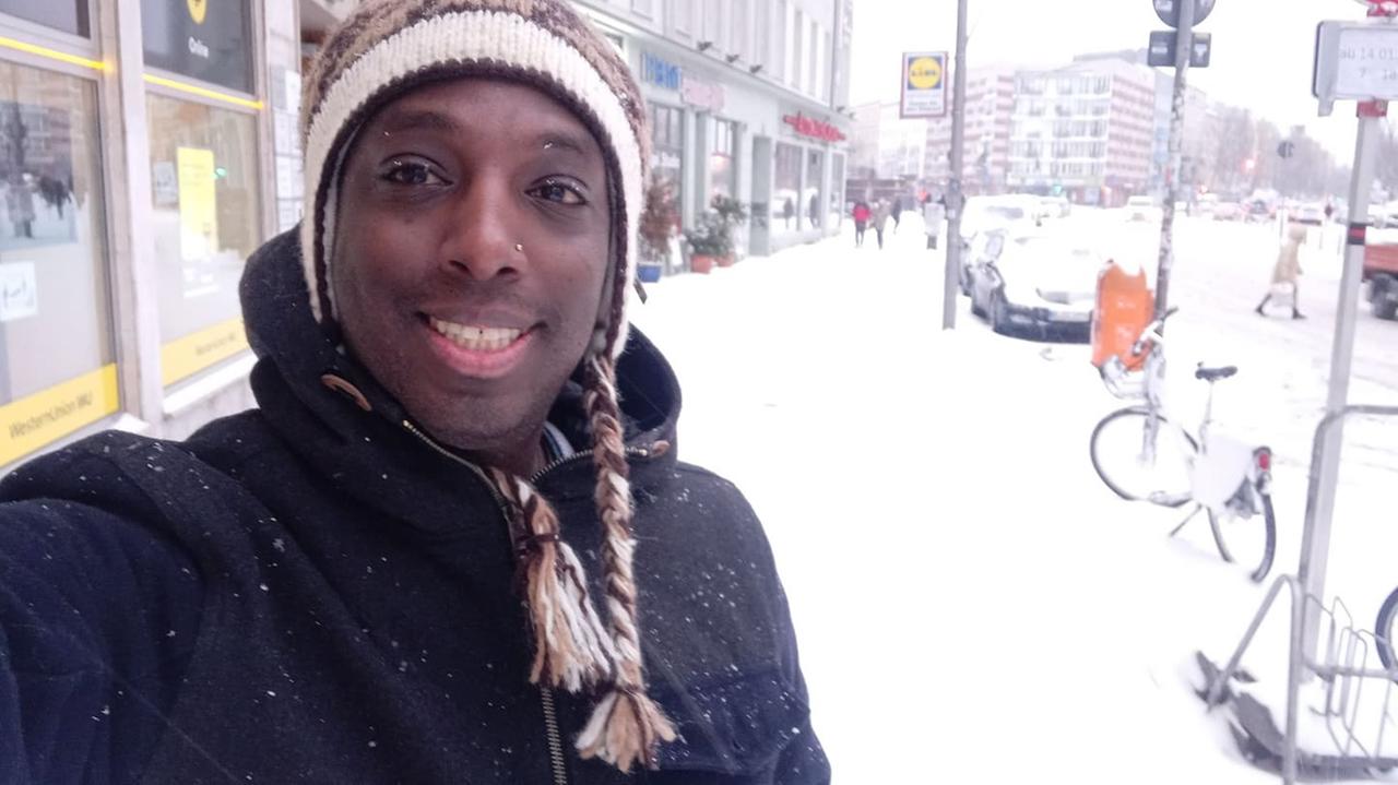 Shmuel Chekol im Februar 2021 in Berlin: Ein junger schwarzer Mann mit Wintermütze in einer verschneiten Straße Shmuel Chekol im Februar 2021 in Berlin: Ein junger schwarzer Mann mit Wintermütze in einer verschneiten Straße