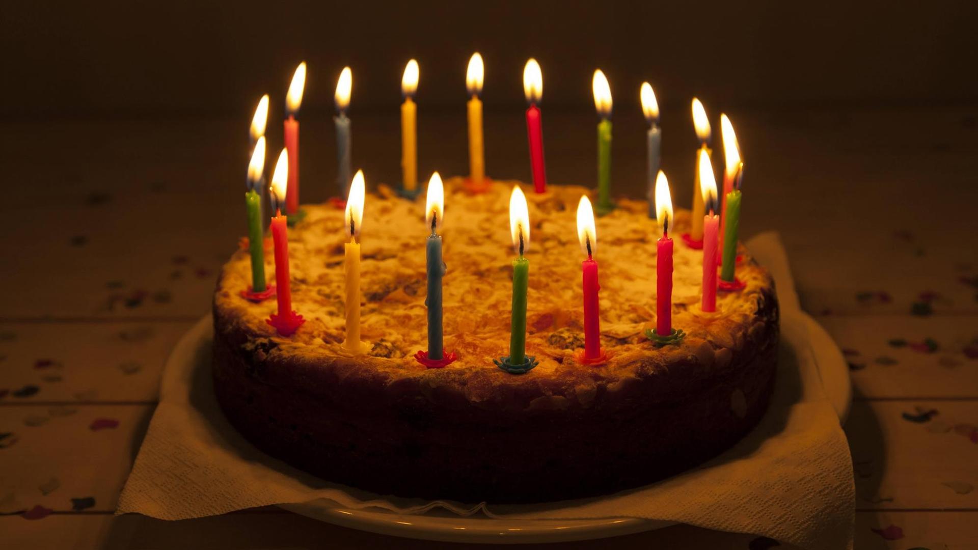 Geburtstagskuchen mit brennenden Kerzen