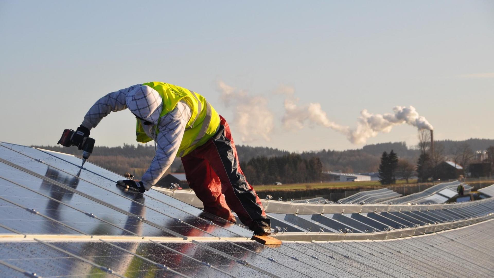 Ein Arbeiter verschraubt Sonnenkollektoren im Solarpark in Leutkirch (Kreis Ravensburg). Ein Arbeiter verschraubt Sonnenkollektoren im Solarpark in Leutkirch (Kreis Ravensburg).