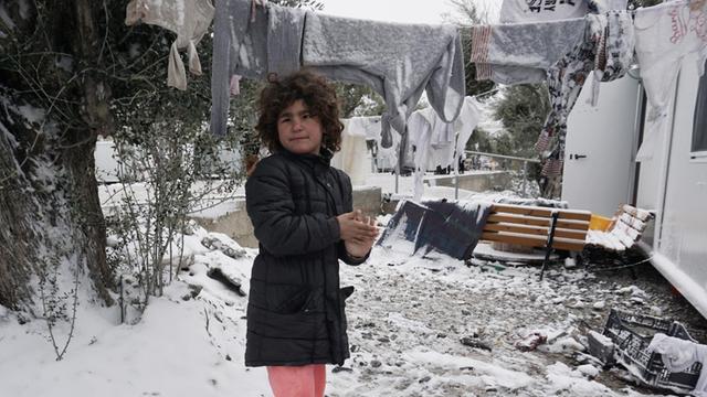 Ein Kind spielt in einem Flüchtlingslager auf der griechischen Insel Lesbos im Schnee.