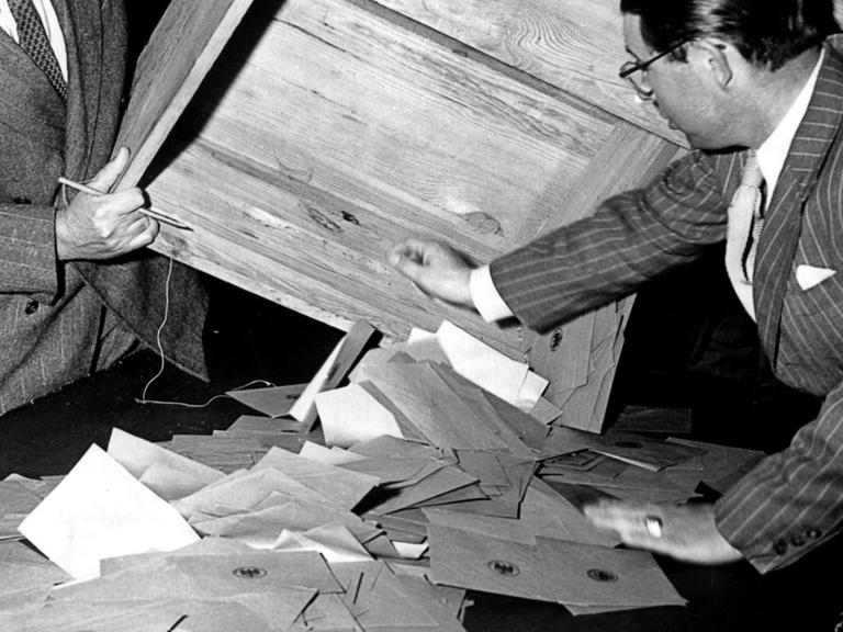 Zwei Wahlhelfer leeren am 14. August 1949 in einem Frankfurter Wahllokal eine Wahlurne zur Stimmauszählung. An diesem Tag fanden in der Bundesrepublik die Wahlen zum ersten Deutschen Bundestag statt.