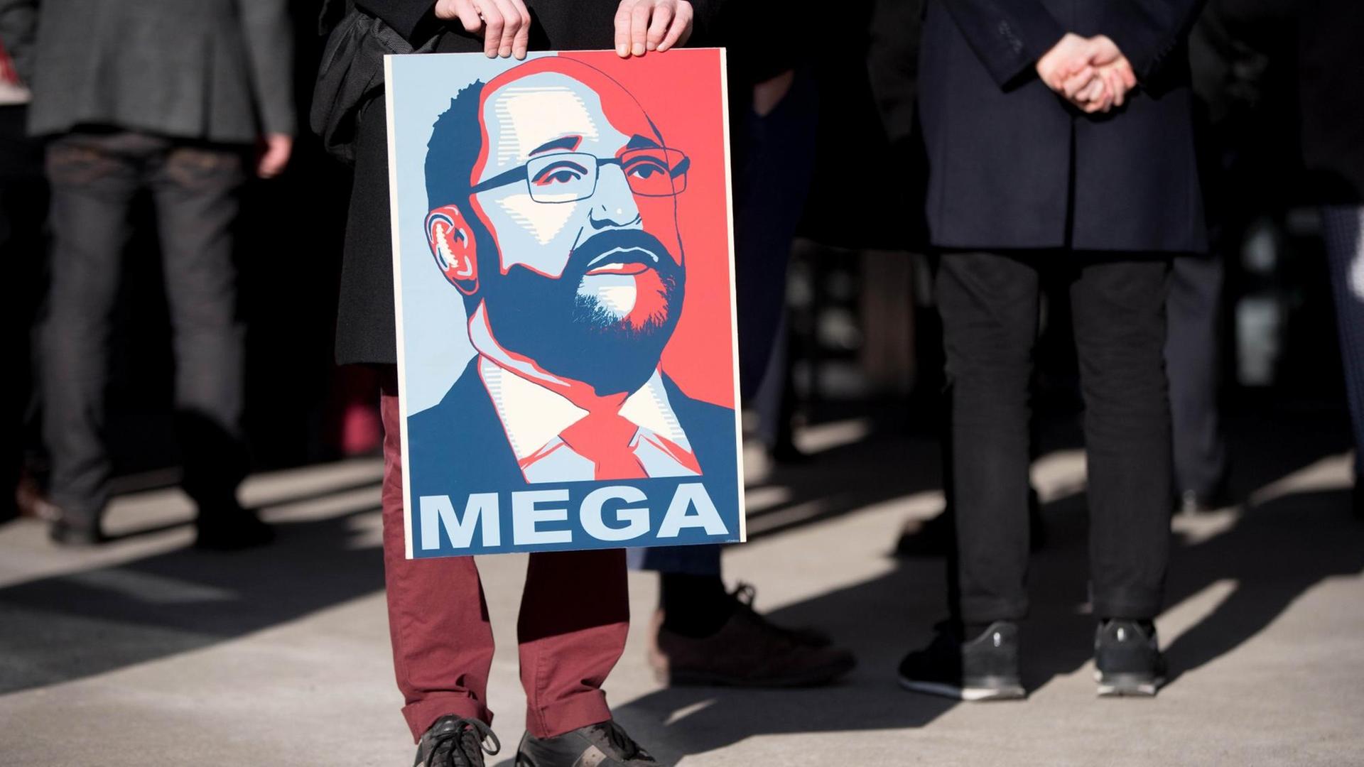 Ein SPD-Parteianhänger hält ein Plakat mit einem Bild des SPD-Kanzlerkandidaten Martin Schulz und der Aufschrift "Mega". Ein SPD-Parteianhänger hält ein Plakat mit einem Bild des SPD-Kanzlerkandidaten Martin Schulz und der Aufschrift "Mega".