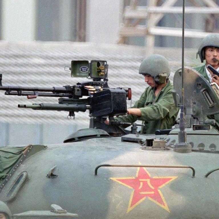 Zwei Soldaten der Volksbefreiungsarmee mit Geschützen auf der Oberfläche eines Panzers 1989 in Peking.