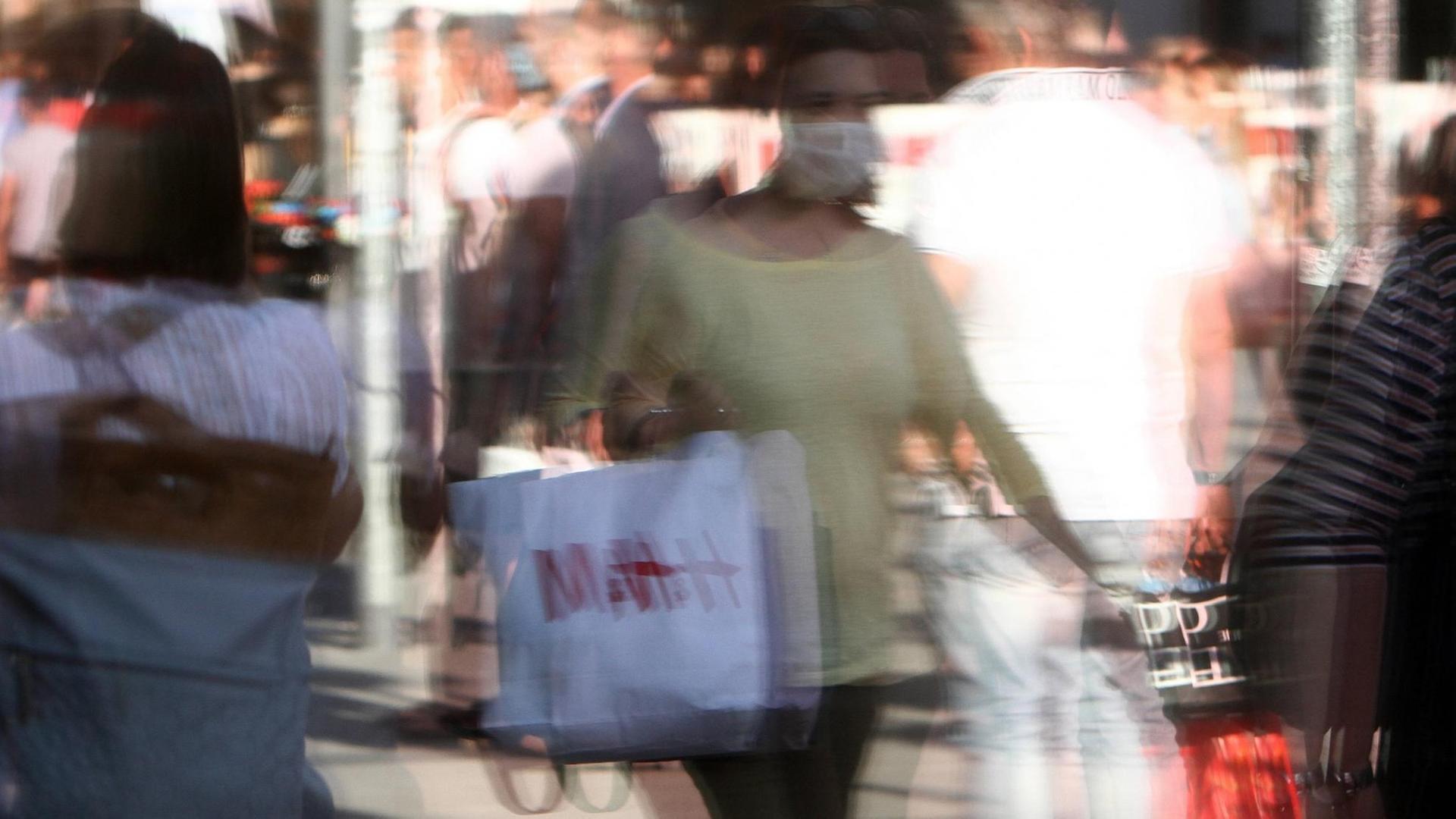 Passanten mit Mundschutz spiegeln sich in einem Schaufenster, Bayern, Deutschland Passanten mit Mundschutz spiegeln sich in einem Schaufenster, Bayern, Deutschland