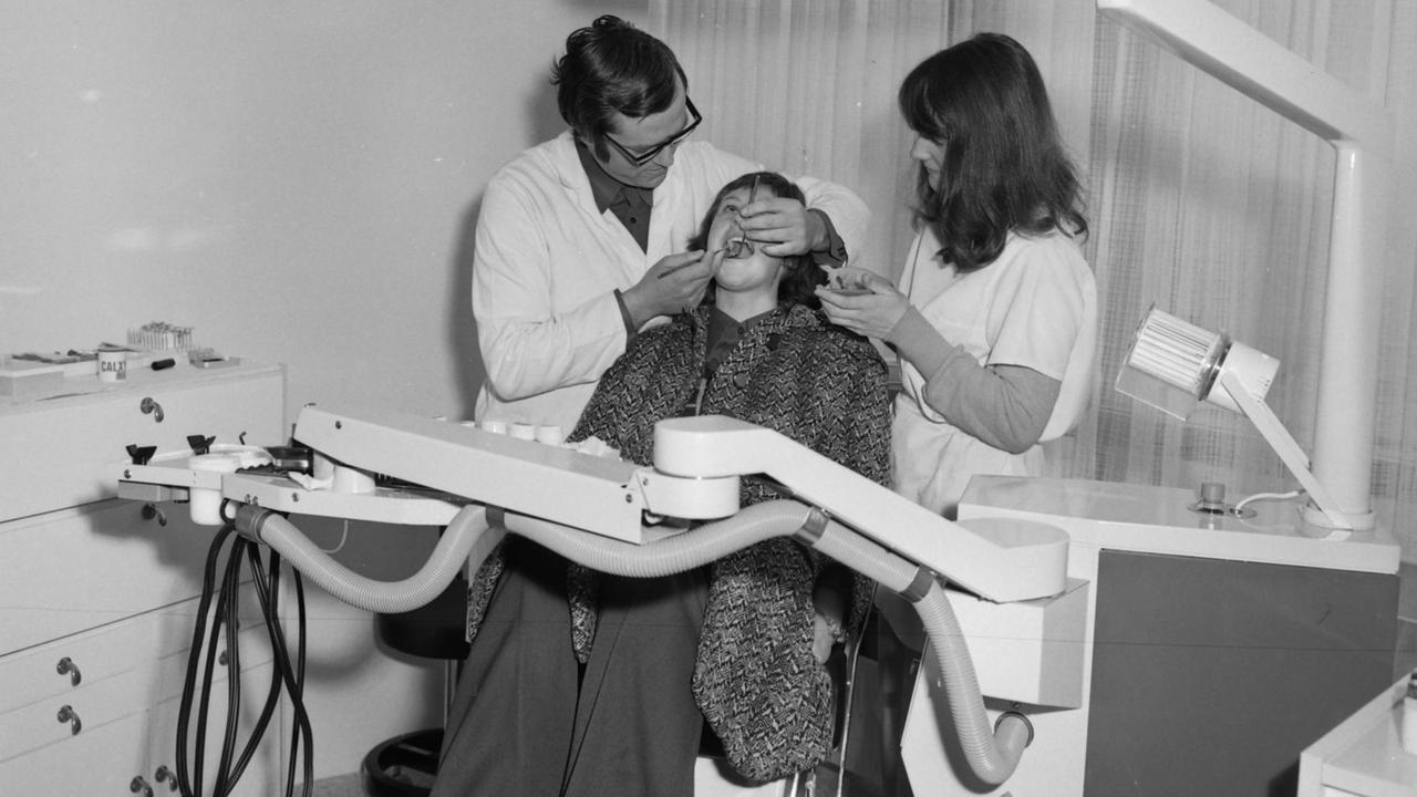 Auf einem Behandlungsstuhl liegend erhält eine Patienten die ärztliche Versorgung für ihre Zähne im Jenaer Universitätshochhaus 1976. Auf einem Behandlungsstuhl liegend erhält eine Patienten die ärztliche Versorgung für ihre Zähne im Jenaer Universitätshochhaus 1976.