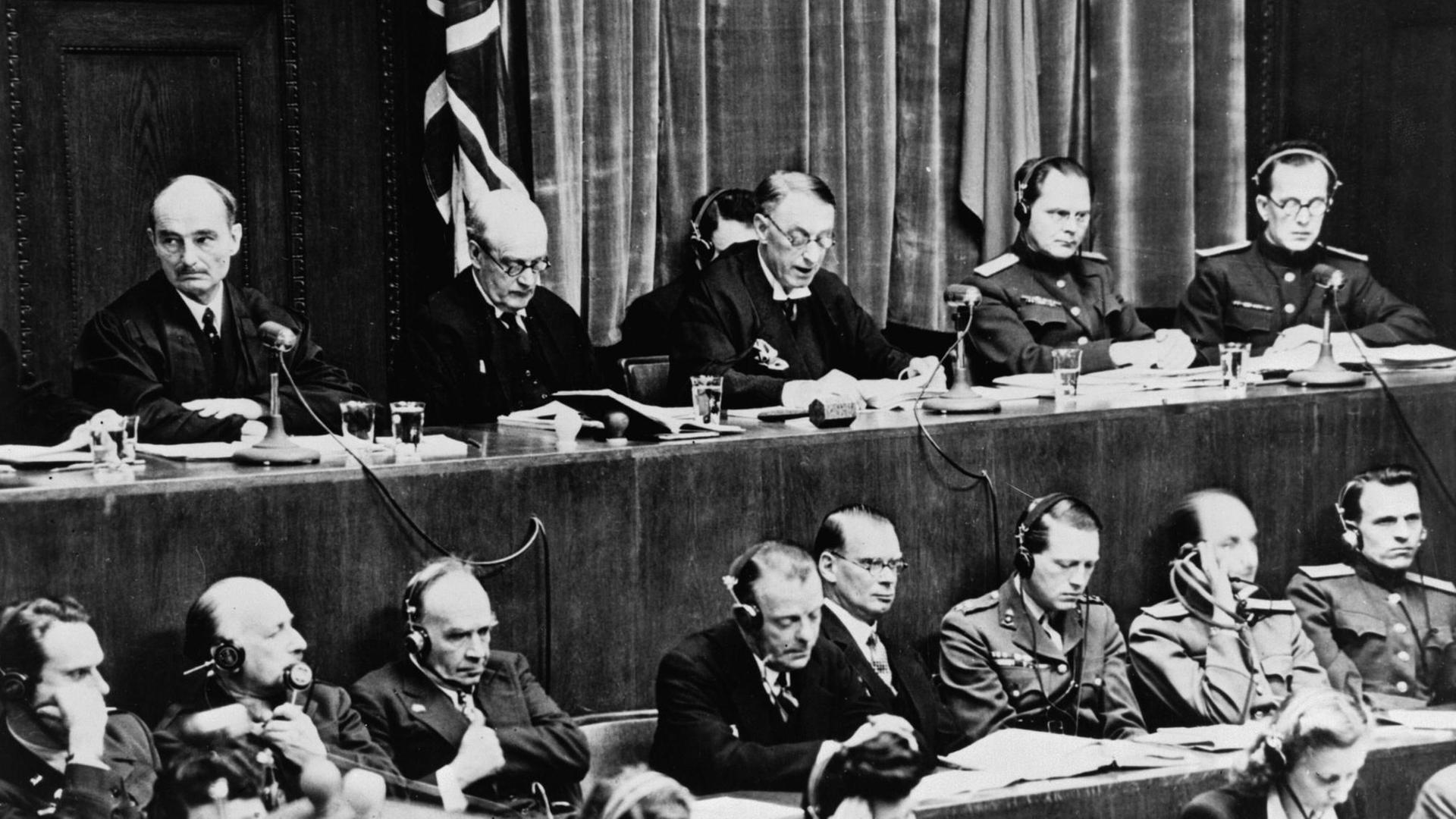 Blick auf die Richterbank im Nürnberger Justizpalast während der Verlesung der Urteilsbegründung, v.l.n.r.: Wolchkow, Nikitschenko (UdSSR), Birkett, Lawrence (GB) und Biddle (USA) Blick auf die Richterbank im Nürnberger Justizpalast während der Verlesung der Urteilsbegründung, v.l.n.r.: Wolchkow, Nikitschenko (UdSSR), Birkett, Lawrence (GB) und Biddle (USA)