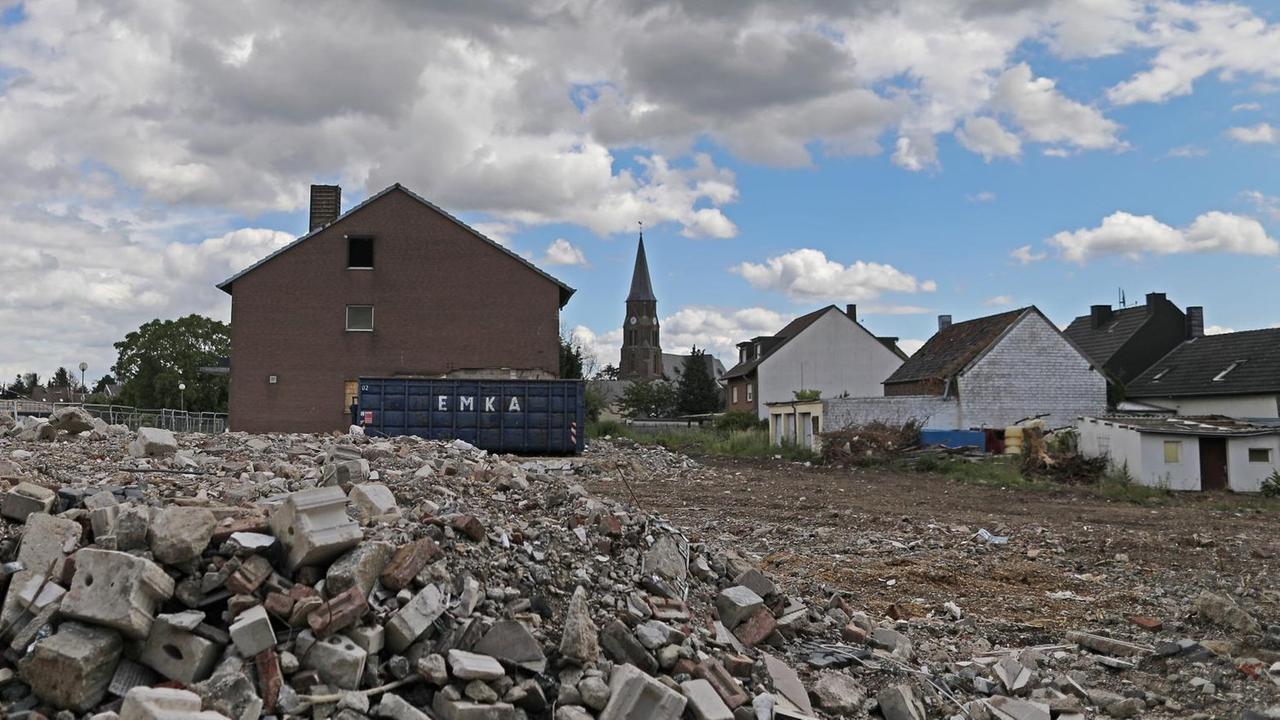 Hinter einem riesigen Schuttfeld in Manheim ragt der Kirchenturm der Gemeinde auf. Hinter einem riesigen Schuttfeld in Manheim ragt der Kirchenturm der Gemeinde auf.