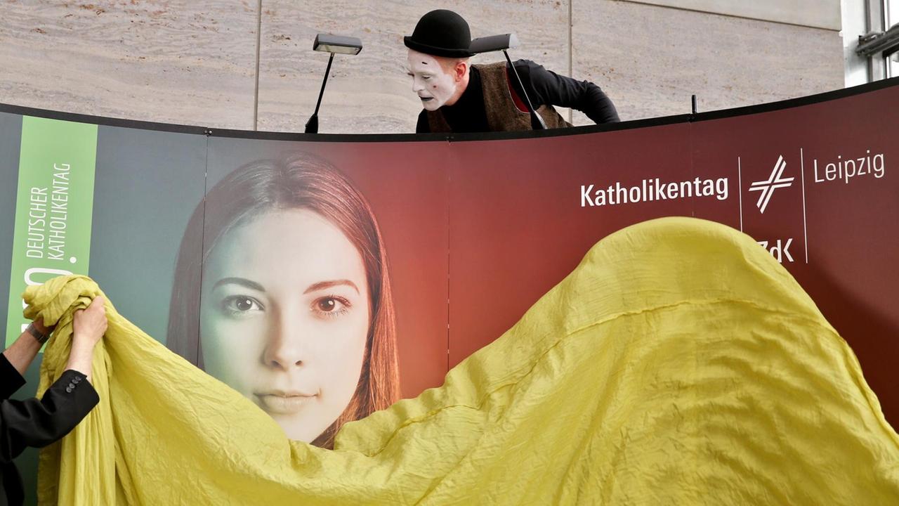 Mit vereinten Kräften enthüllen Erzbischof Heiner Koch und der Pantomime Martin Kiefer am 08.07.2015 ein Plakat für den 100. Deutschen Katholikentag 2016 in Leipzig (Sachsen). Unter dem Motto "Seht, da ist der Mensch" werden vom 25. bis 29. Mai 2016 werden mehrere Zehntausend Gäste zu der christlichen Großveranstaltung in der Messestadt erwartet. Mit vereinten Kräften enthüllen Erzbischof Heiner Koch und der Pantomime Martin Kiefer am 08.07.2015 ein Plakat für den 100. Deutschen Katholikentag 2016 in Leipzig (Sachsen). Unter dem Motto "Seht, da ist der Mensch" werden vom 25. bis 29. Mai 2016 werden mehrere Zehntausend Gäste zu der christlichen Großveranstaltung in der Messestadt erwartet.