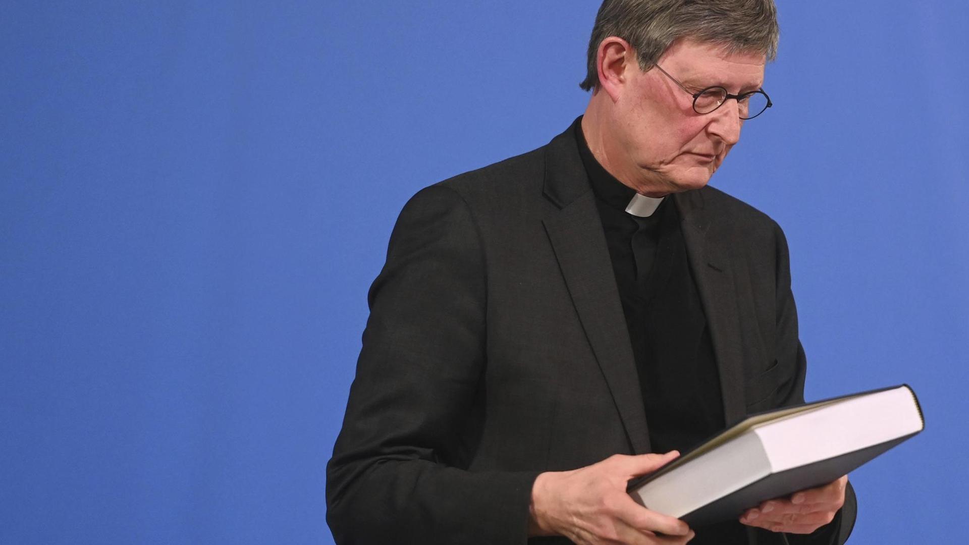 Kardinal Rainer Maria Woelki hält das Gutachten kurz nach der Veröffentlichung in der Hand. Kardinal Rainer Maria Woelki hält das Gutachten kurz nach der Veröffentlichung in der Hand.