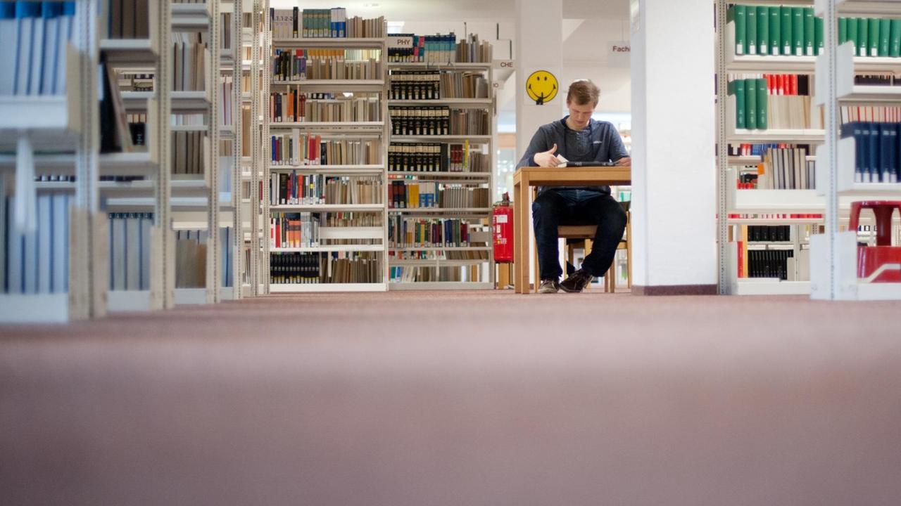 Ein Student sitzt am 07.11.2012 in der Bibliothek der Universität Hildesheim an einem Schreibtisch und liest. Ein Student sitzt am 07.11.2012 in der Bibliothek der Universität Hildesheim an einem Schreibtisch und liest.