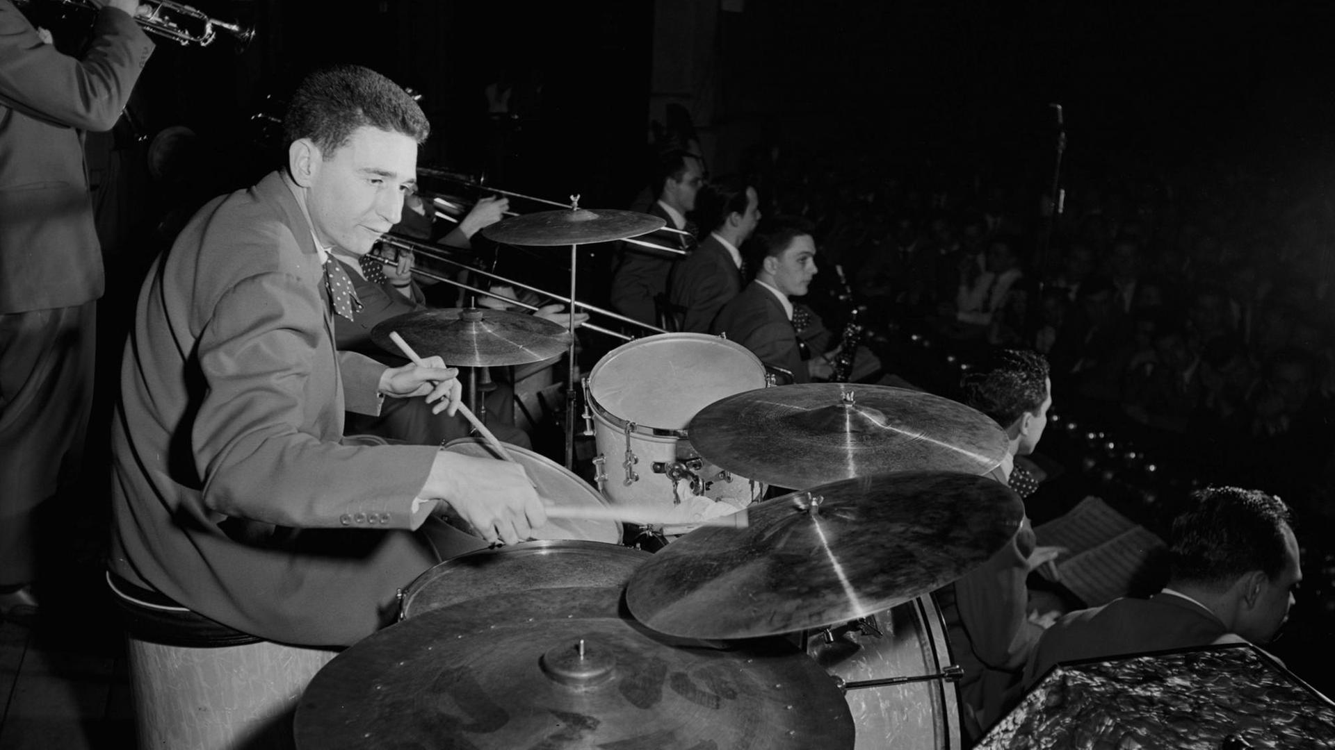 Schwarz-weiß-Porträt des Schlagzeugers Shelly Manne, am Schlagzeug. Schwarz-weiß-Porträt des Schlagzeugers Shelly Manne, am Schlagzeug.