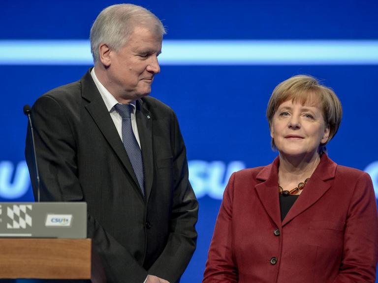 Bundeskanzlerin Angela Merkel (CDU) unterhält sich am 20.11.2015 auf dem CSU-Parteitag in München (Bayern) mit dem bayerischen Ministerpräsidenten Horst Seehofer (CSU).