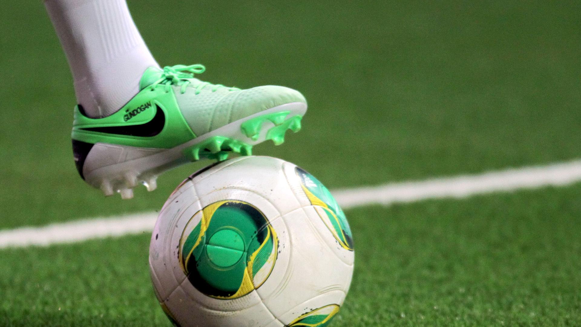 Ein Fußballschuh angelegt auf einem Fußball. Ein Fußballschuh angelegt auf einem Fußball.