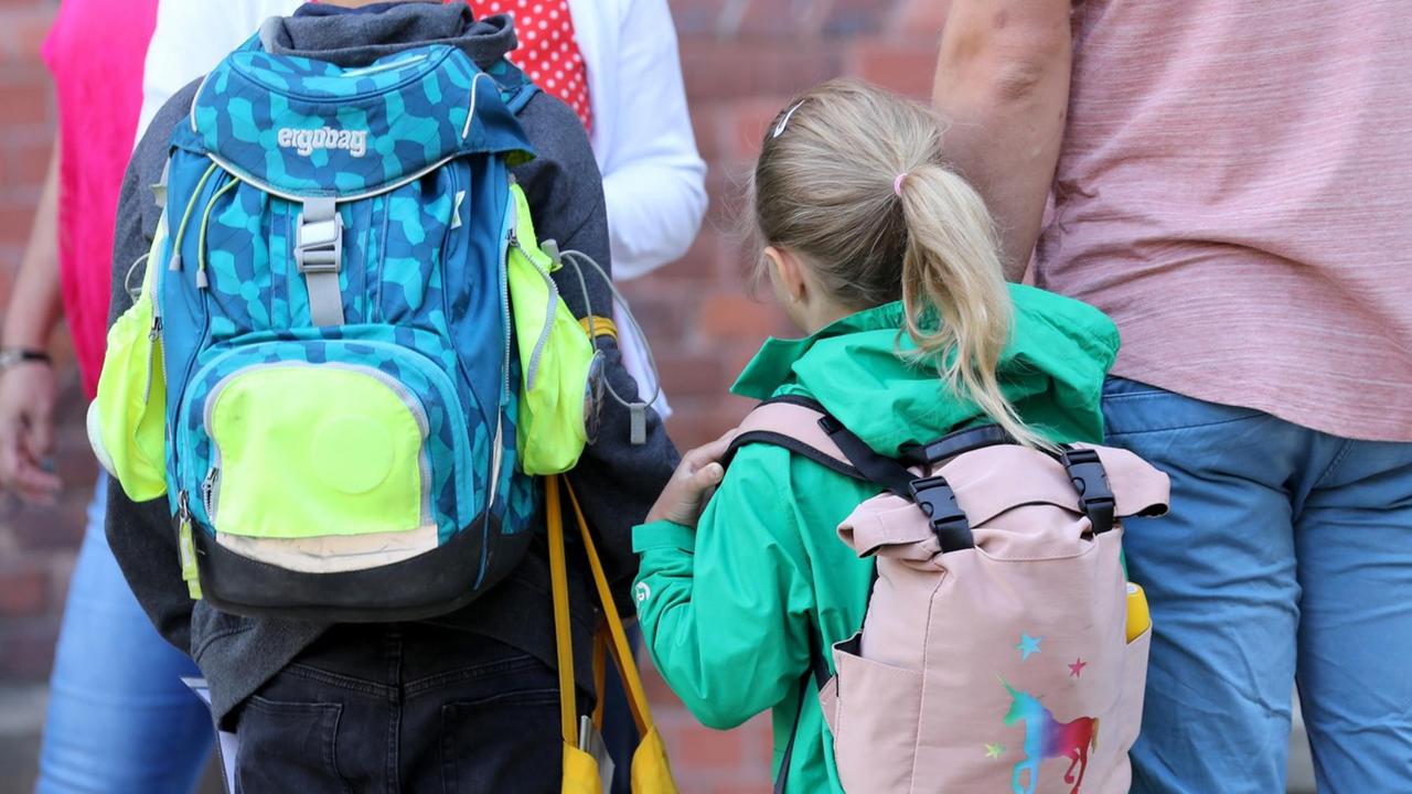 In Rostock werden Schüler von ihren Eltern zur Schule gebracht. Die Gesichter sind auf dem Foto nicht zu erkennen. In Rostock werden Schüler von ihren Eltern zur Schule gebracht. Die Gesichter sind auf dem Foto nicht zu erkennen.