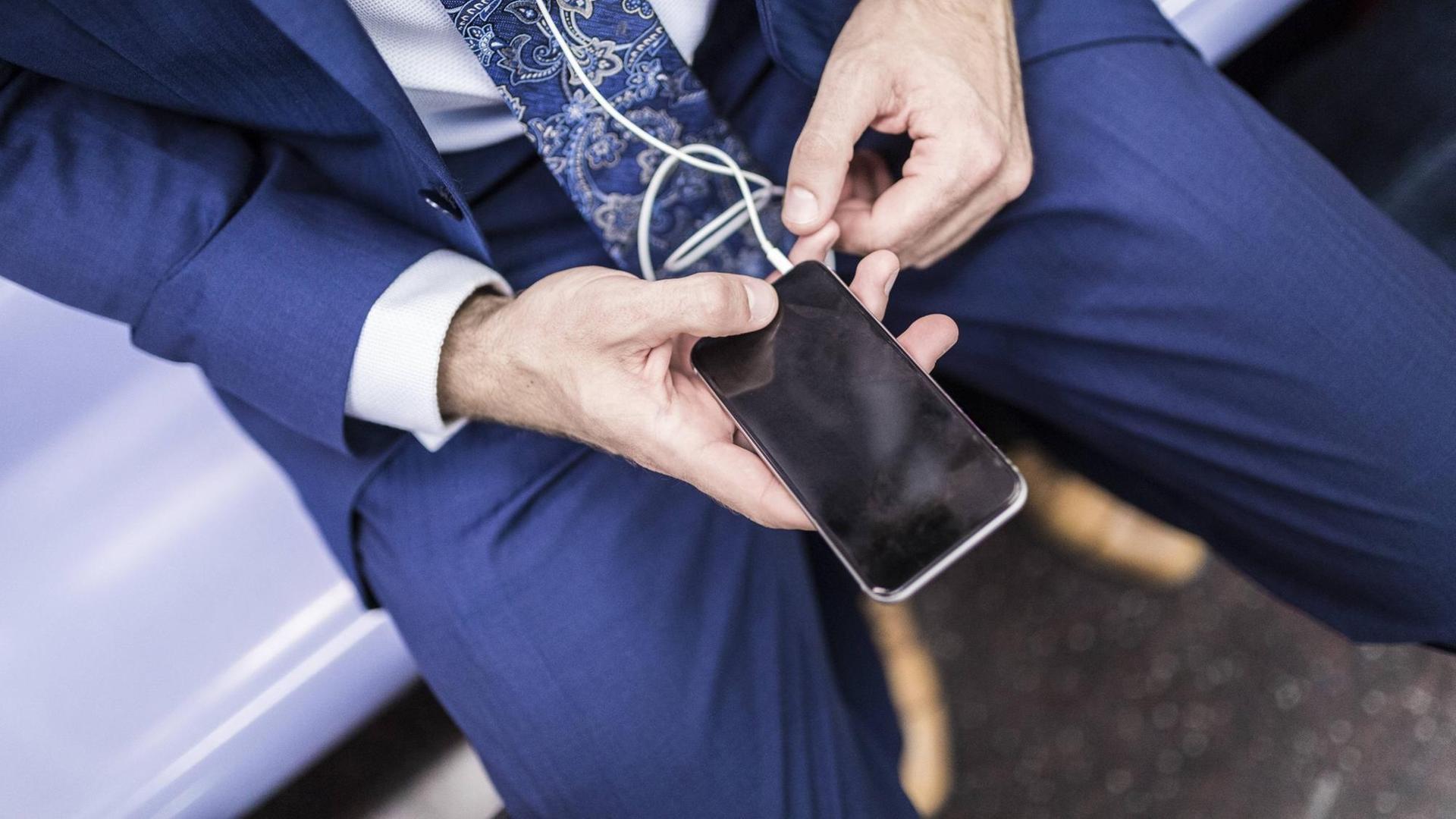 Ein Mann blickt auf sein Smartphone Ein Mann blickt auf sein Smartphone