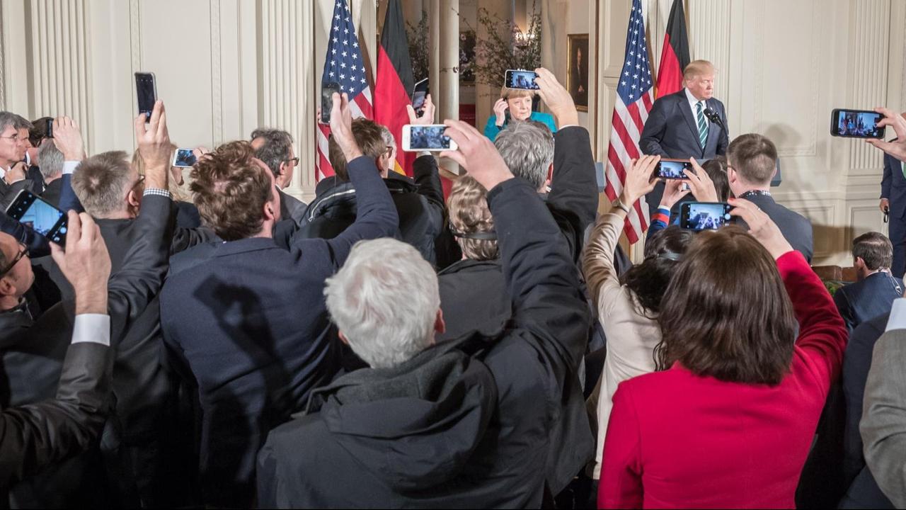 Journalisten fotografieren US-Präsident Donald Trump und Bundeskanzlerin Angela Merkel mit ihren Smartphones. Journalisten fotografieren US-Präsident Donald Trump und Bundeskanzlerin Angela Merkel mit ihren Smartphones.
