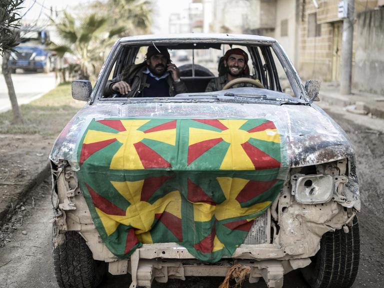 Zwei Kurden in einem kaputten Auto in Kobane