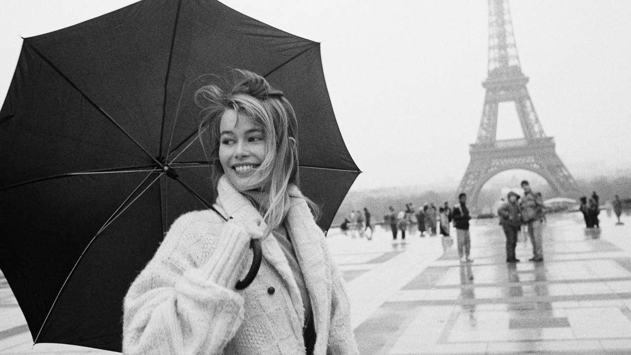Claudia Schiffer an einem regnerischen Tag in Paris vor dem Eiffelturm, 1990. 