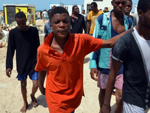 Migranten aus Subsahara-Afrika kommen im Hafen der tunesischen Stadt Ben Guerdane an, nachdem sie von der tunesischen Küstenwache aus dem Mittelmeer vor Libyen gerettet wurden