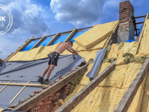 Dachdecker dämmen das Dach eines Hauses in Cottbus mit Glaswolle