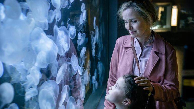 Julie Delpy steht in "My Zoe" gemeinsam mit ihrer Filmtochter vor einem Aquarium mit Quallen. Julie Delpy steht in "My Zoe" gemeinsam mit ihrer Filmtochter vor einem Aquarium mit Quallen.
