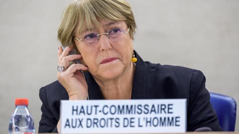 UNO-Hochkommissarin für Menschenrechte, Michelle Bachelet, sitzt an einem Schreibtisch und telefoniert mit einem Handy.