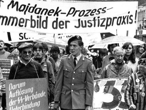 Demonstration vor der Urteilsverkündung im Majdanek-Prozess: Menschen mit einem Banner: "Der Majdanek-Prozess - Jammerbild der Justizpraxis"