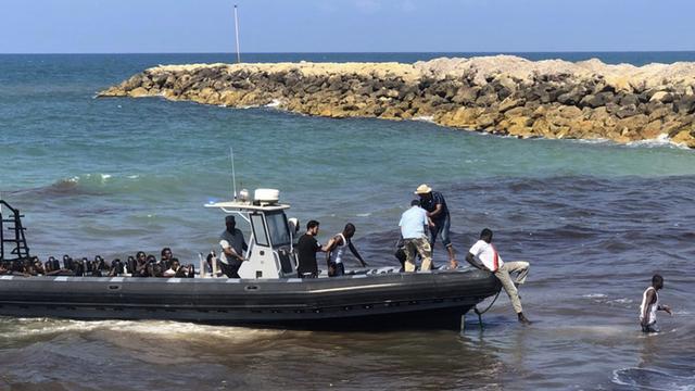 Dieses von der libyschen Küstenwache zur Verfügung gestellte Foto zeigt eine Gruppe afrikanischer Migranten, die von der Küstenwache im Osten der libyschen Hauptstadt in einem Boot an Land gebracht werden.
