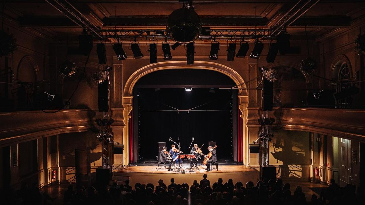 Im ehemaligen Ballsaal spielt das Quartett in einem festlich beleuchteten Raum