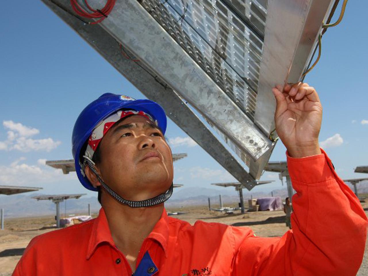 Ein Arbeiter prüft ein Solarpanel auf einem Feld im chinesischen Hami. Ein Arbeiter prüft ein Solarpanel auf einem Feld im chinesischen Hami.