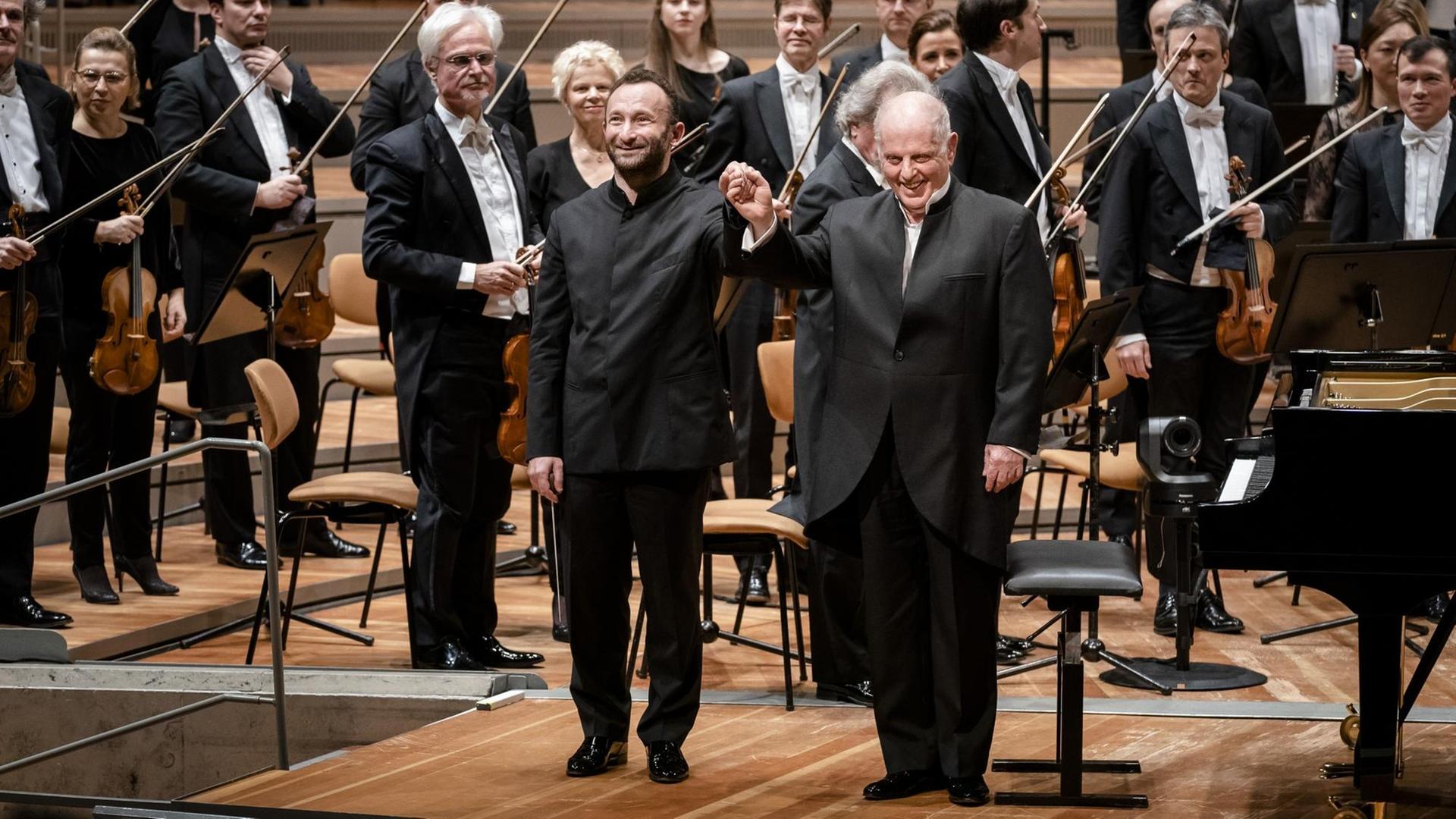 Dirigent und Pianist stehen vor dem Orchester. Dirigent und Pianist stehen vor dem Orchester.