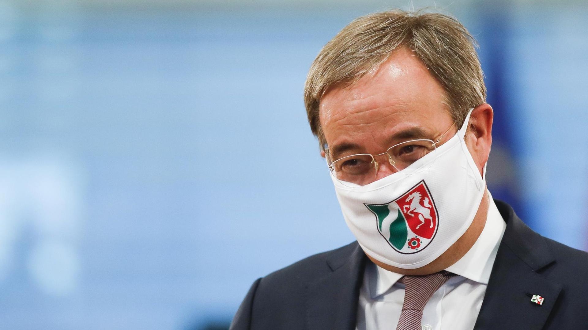 Armin Laschet, Ministerpräsident von Nordrhein-Westfalen, trägt eine Gesichtsmaske mit dem Wappen von Nordrhein-Westfalen, als er zu einer Gesprächsrunde zwischen Bundeskanzlerin Merkel und Ministerpräsidenten der Bundesländer im Kanzleramt eintrifft.