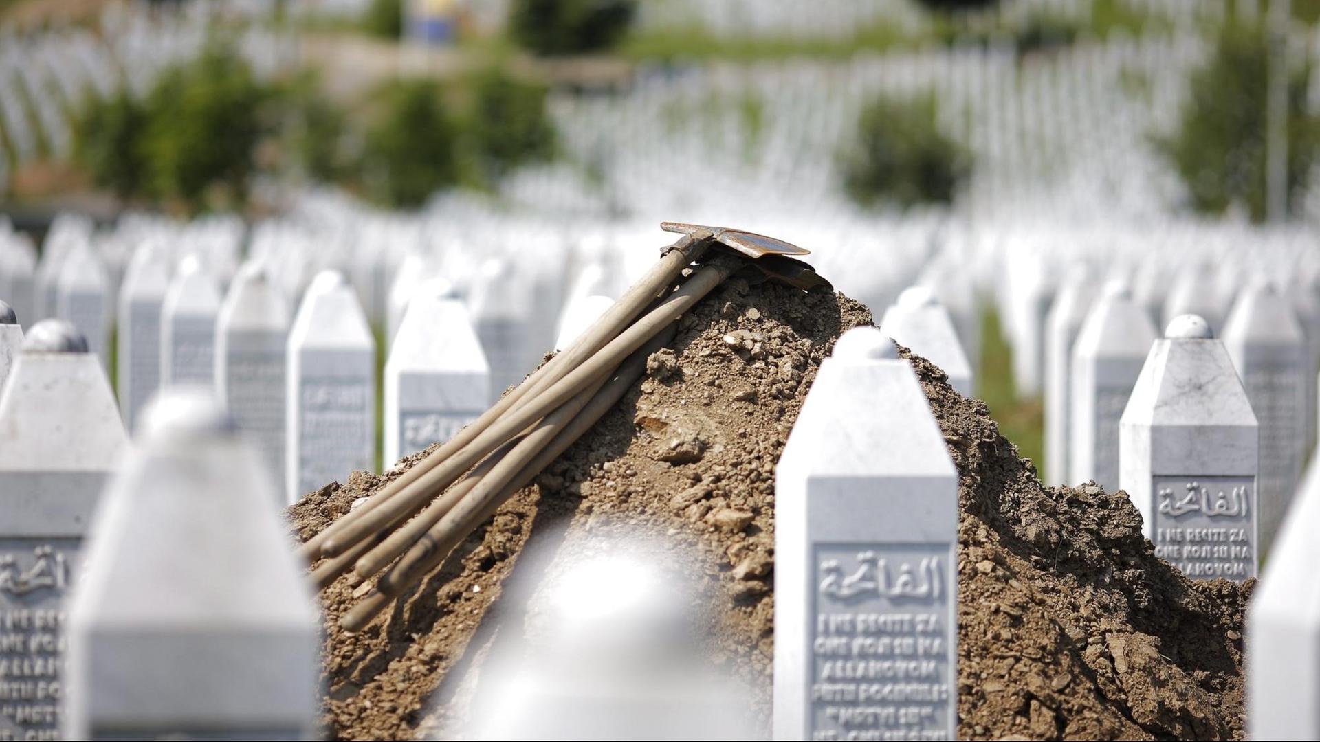 Schaufeln liegen auf einem Grab in Srebrenica.