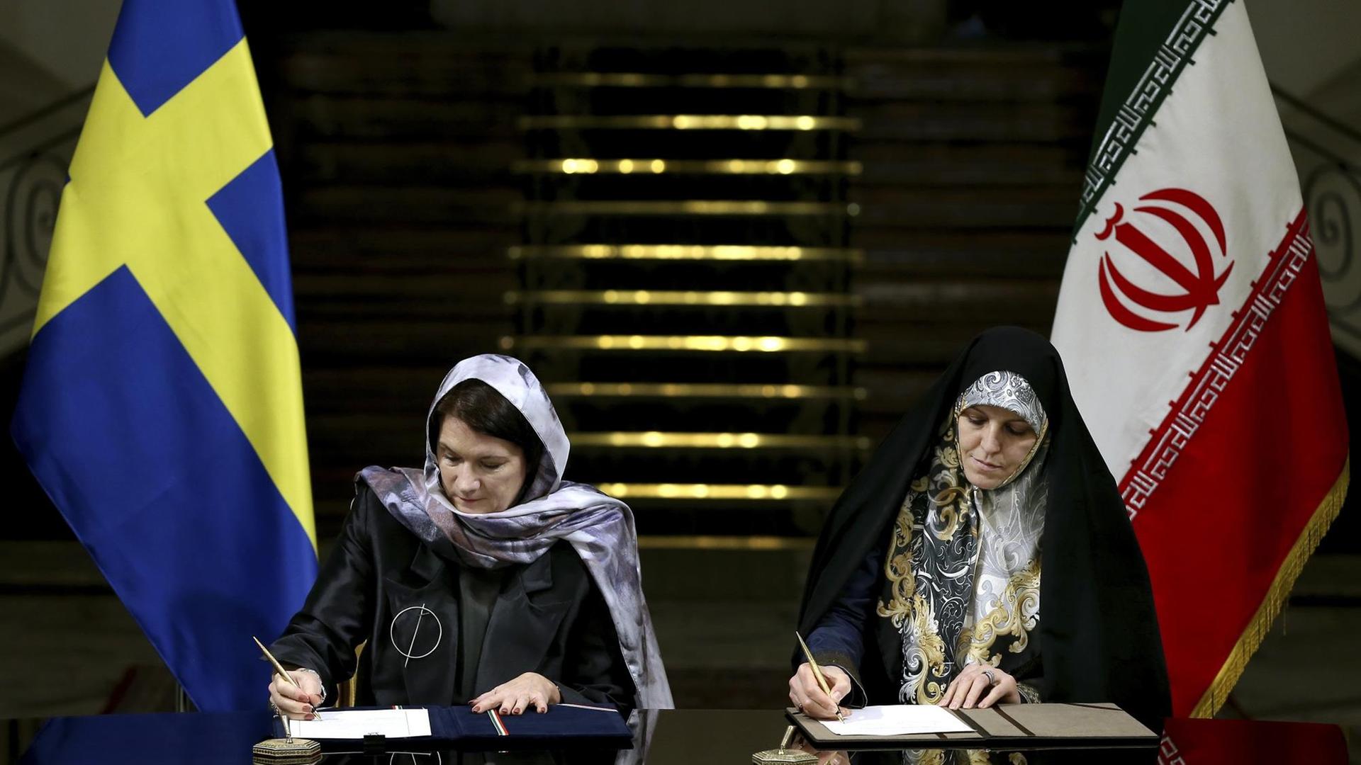 Die schwedische Handelsministerin Ann Linde und Irans Vizepräsidentin für Frauen- und Familienangelegenheiten, Shahindokht Molaverdi, unterzeichnen ein Abkommen in Teheran. Die schwedische Handelsministerin Ann Linde und Irans Vizepräsidentin für Frauen- und Familienangelegenheiten, Shahindokht Molaverdi, unterzeichnen ein Abkommen in Teheran.