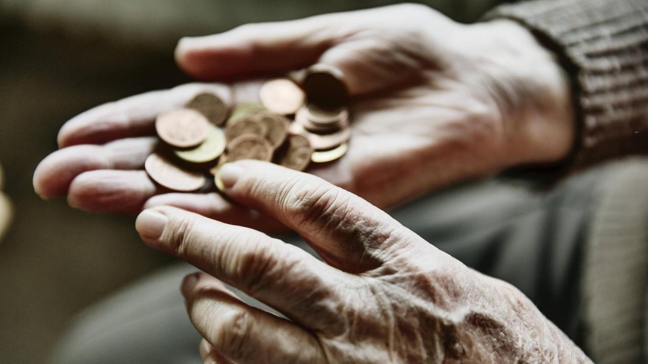 Nahaufnahme der Hand einer alten Frau, die ein paar Münzen zählt. Nahaufnahme der Hand einer alten Frau, die ein paar Münzen zählt.