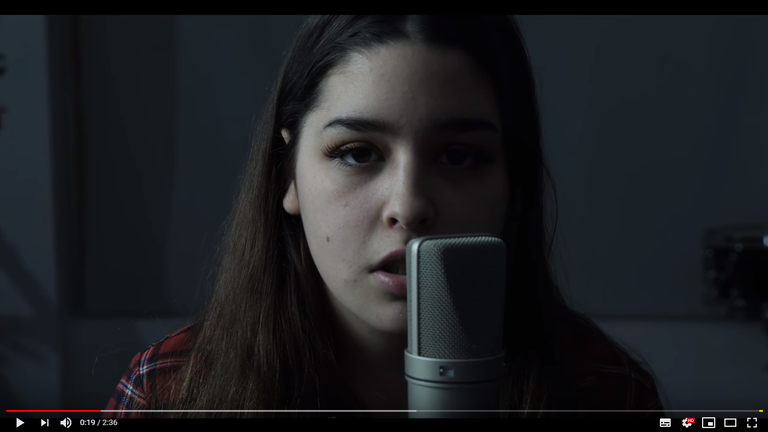 Still von Emma Stevens am Mikrofon aus dem "Blackbird"-Video auf Youtube der Allison Bernard Memorial High School Still von Emma Stevens am Mikrofon aus dem "Blackbird"-Video auf Youtube der Allison Bernard Memorial High School