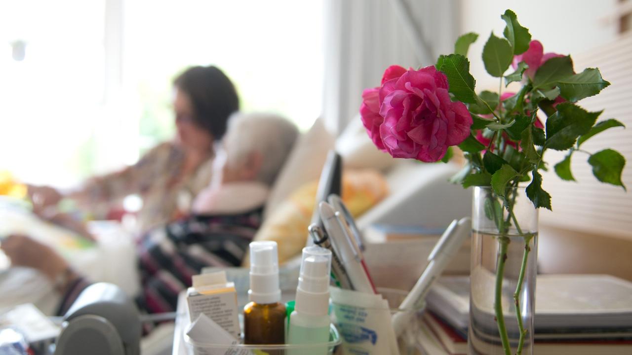 Eine Kunsttherapeutin zeichnet mit einer Frau in einem Hospiz ein Bild. Eine Kunsttherapeutin zeichnet mit einer Frau in einem Hospiz ein Bild.
