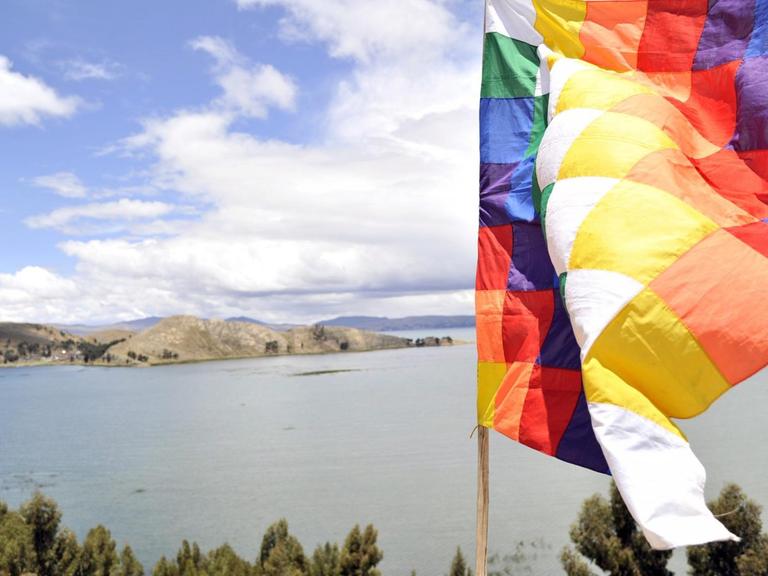 Der Titicacasee und im Vordergrund eine bunte Fahne.